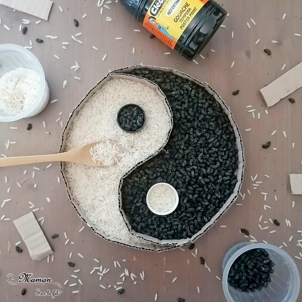 Activité créative, manuelle et sensorielle enfants - Yin et Yang chinois en carton, riz et pâtes colorées - Colore le symbole en transvasant le riz et les pâtes dans les cases et les bouchons - maniement de la cuillère - motricité fine, transvasement et créativité - Asie et Chine - Découverte d'un pays - Espace et géographie - bricolage et sensoriel - arts visuels et atelier maternelle et Cycle 2 - Emotions - mslf