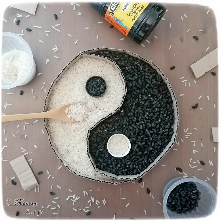 Activité créative, manuelle et sensorielle enfants - Yin et Yang chinois en carton, riz et pâtes colorées - Colore le symbole en transvasant le riz et les pâtes dans les cases et les bouchons - maniement de la cuillère - motricité fine, transvasement et créativité - Asie et Chine - Découverte d'un pays - Espace et géographie - bricolage et sensoriel - arts visuels et atelier maternelle et Cycle 2 - Emotions - mslf