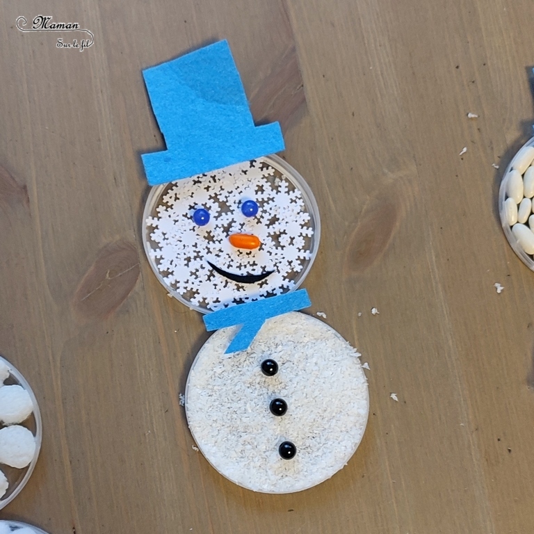 Activité créative et manuelle enfants -Fabriquer des bonhommes de neige sensoriels en récup' - Bouchons en plastique de Boite de chips type Pringles - Matériel créatif divers - haricots blancs, fausse neige, flocons, pompons, playmais, coton - Accessoires en feutrine et perles - Collage et art éphémère - Hiver, banquise, froid, neige - Arts visuels Maternelle et élémentaire - Créativité - Cycle 1 ou 2 - mslf