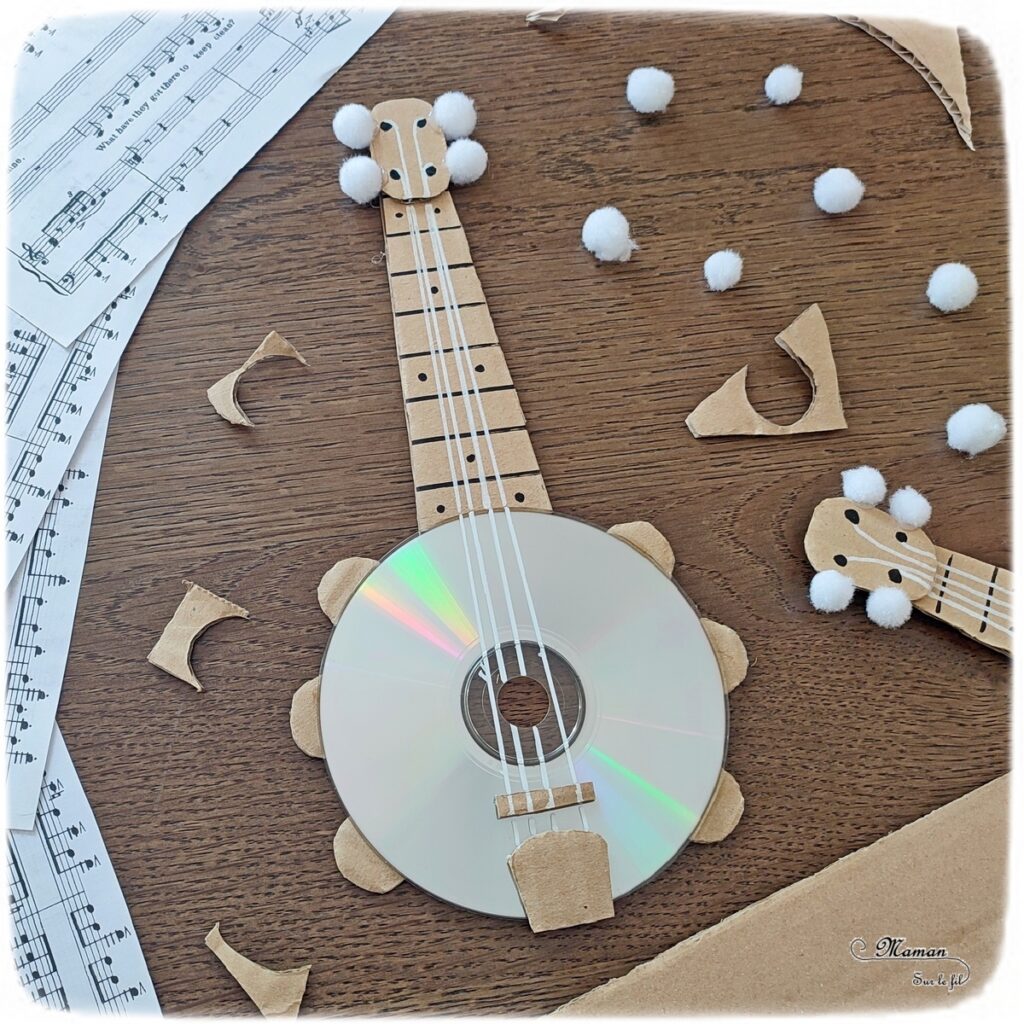 Activité créative et manuelle enfants - Fabriquer des banjos avec des CD et du carton - Bricolage récup' avec des pompons - Récup, recyclage, surcyclage - Découpage, bricolage, collage - Bricolage facile et rapide pour un thème sur la fête de la musique - Arts visuels et atelier Maternelle et élémentaire - Créativité - Cycle 1 ou 2 - tutoriel photos - mslf