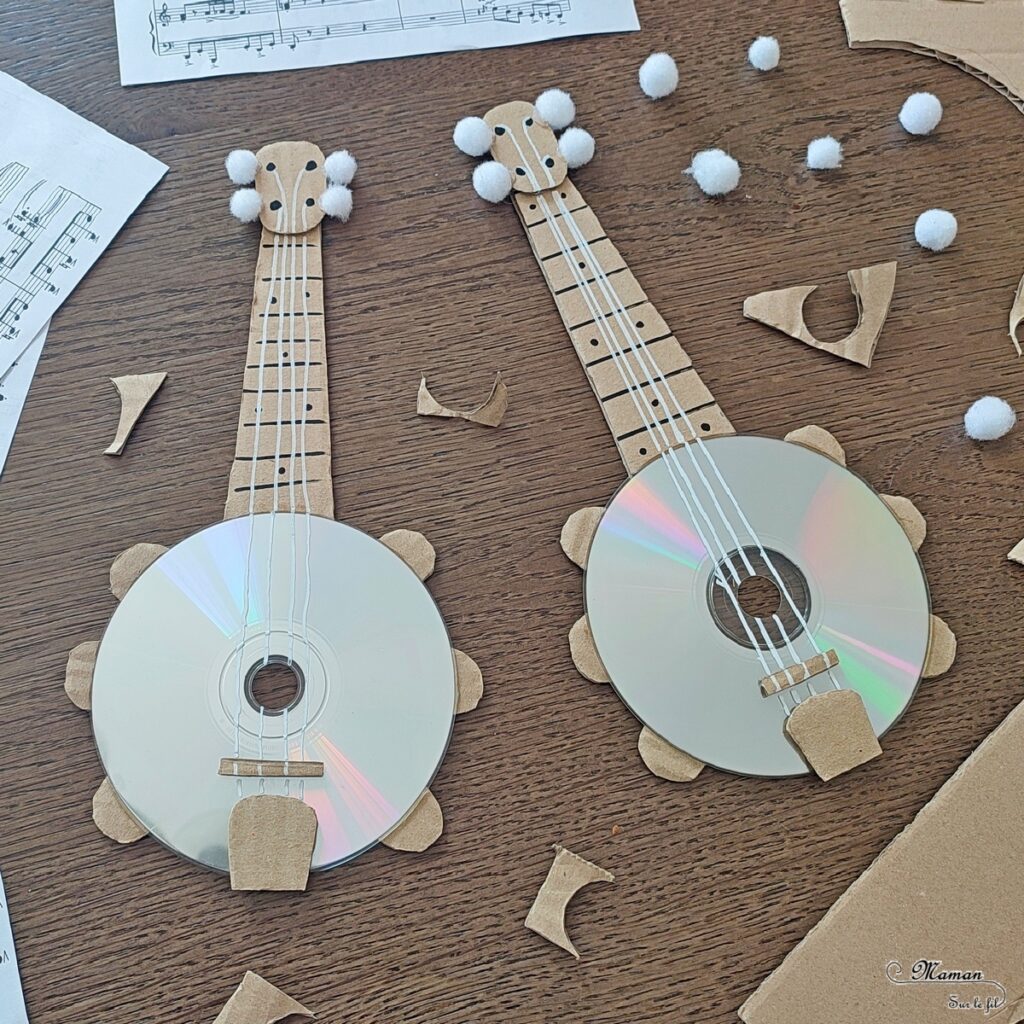 Activité créative et manuelle enfants - Fabriquer des banjos avec des CD et du carton - Bricolage récup' avec des pompons - Récup, recyclage, surcyclage - Découpage, bricolage, collage - Bricolage facile et rapide pour un thème sur la fête de la musique - Arts visuels et atelier Maternelle et élémentaire - Créativité - Cycle 1 ou 2 - tutoriel photos - mslf