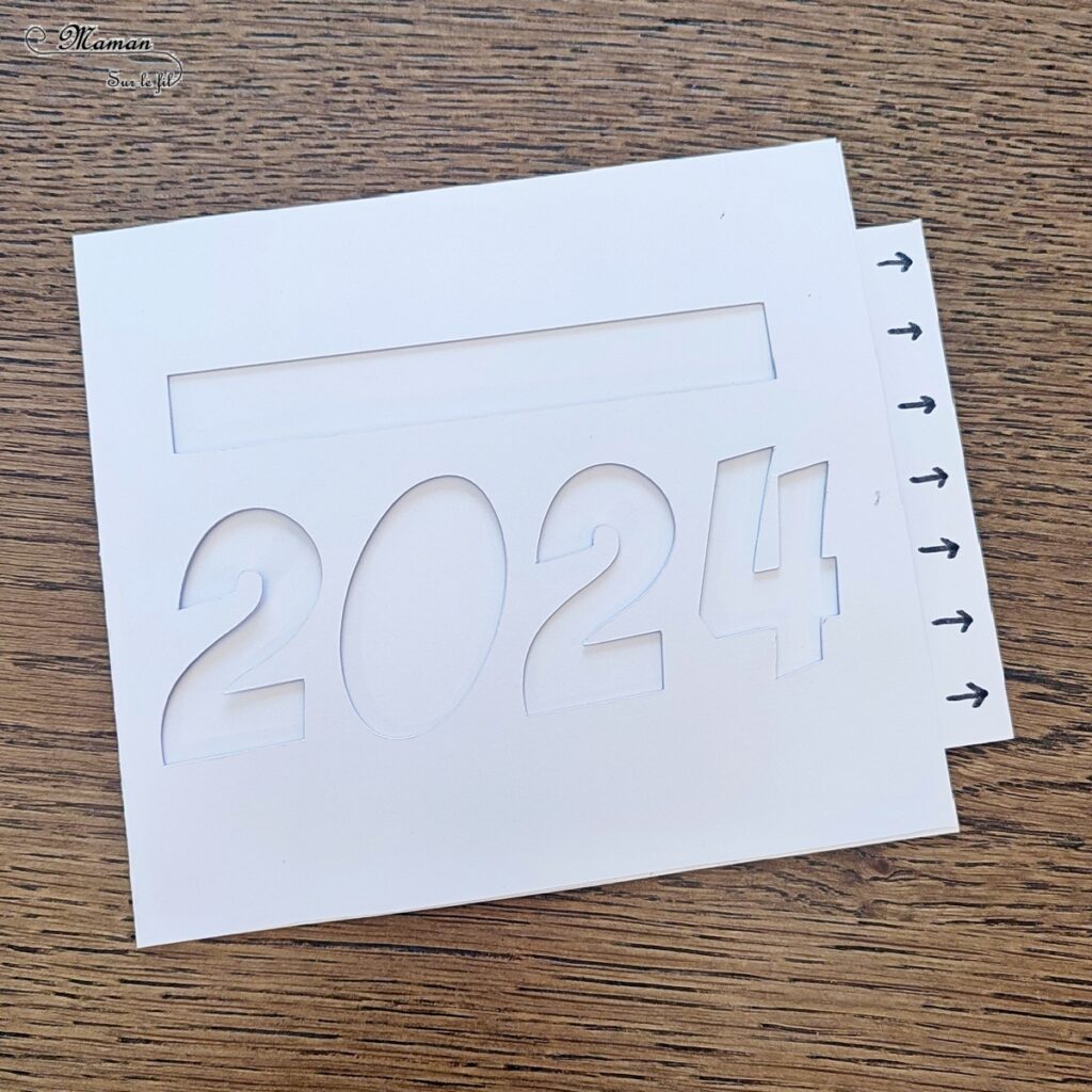 Fabriquer une carte surprise pour fêter la nouvelle année : activité créative et manuelle enfants - Bricolage d'une carte DIY qui se colore et laisse apparaître un message de bonne année quand on tire la languette comme indiqué - Carte de voeux fait maison rigolote et ludique - Découpage et collage - Récup' de chutes de papier coloré - Arts visuels et Bricolage maternelle ou élémentaire (cycles 1, 2 et 3) - Thème Nouvelle année, bonne année, nouvel an - Créativité - tutoriel photos et vidéos - mslf