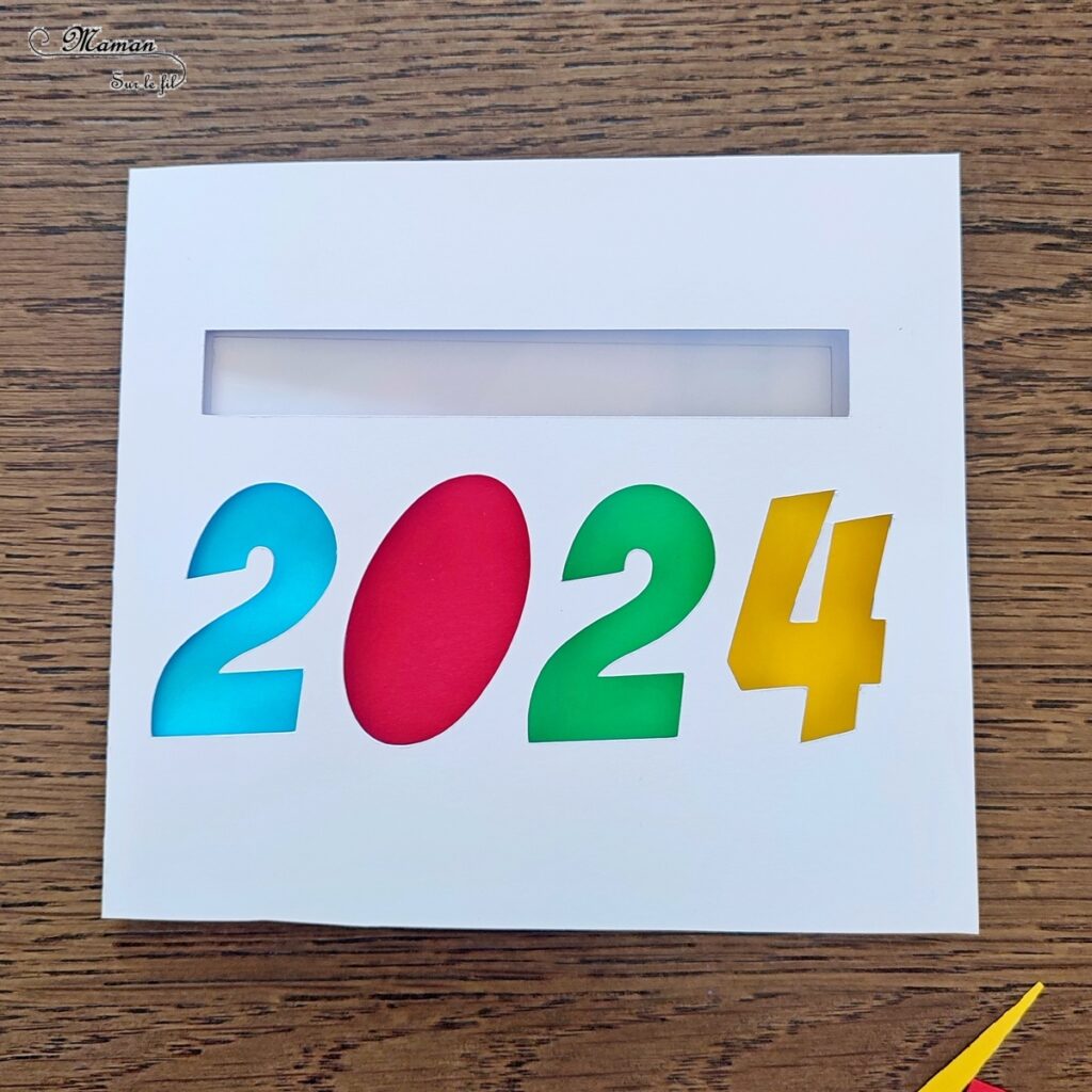 Fabriquer une carte surprise pour fêter la nouvelle année : activité créative et manuelle enfants - Bricolage d'une carte DIY qui se colore et laisse apparaître un message de bonne année quand on tire la languette comme indiqué - Carte de voeux fait maison rigolote et ludique - Découpage et collage - Récup' de chutes de papier coloré - Arts visuels et Bricolage maternelle ou élémentaire (cycles 1, 2 et 3) - Thème Nouvelle année, bonne année, nouvel an - Créativité - tutoriel photos et vidéos - mslf