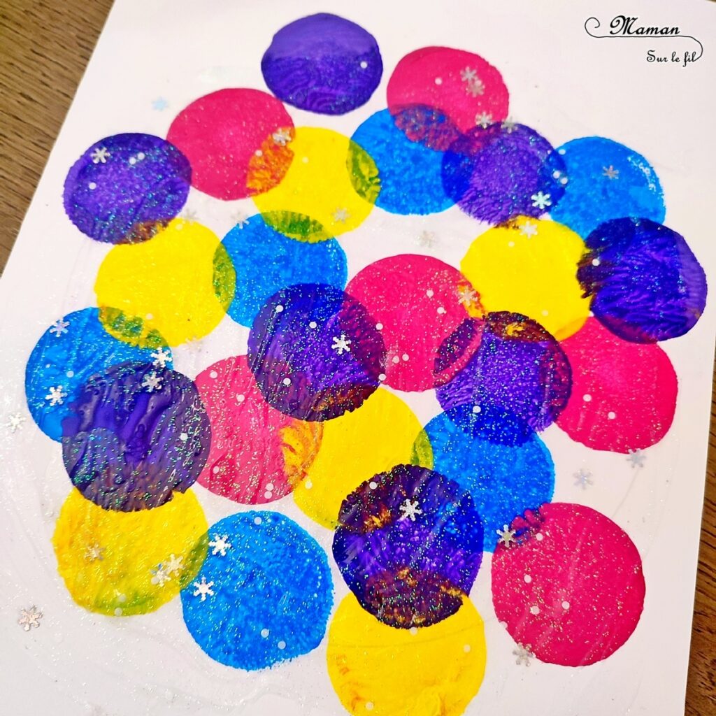 Activité créative, manuelle enfants - Roue de sapins perforés qui changent de couleurs - Papier et système qui tournent au dos - Perforatrice et peinture au tampon - Gel pailleté - Décorations, boules qui changent de couleurs - Jeu et atelier DIY - Pour patienter avant Noël - Récup' - Arts visuels - Thème hiver, Avent, Noël, sapins - Bricolage facile - Arts visuels et atelier Maternelle et élémentaire - Créativité - Cycle 1 ou 2 - tutoriel photos et vidéo - mslf