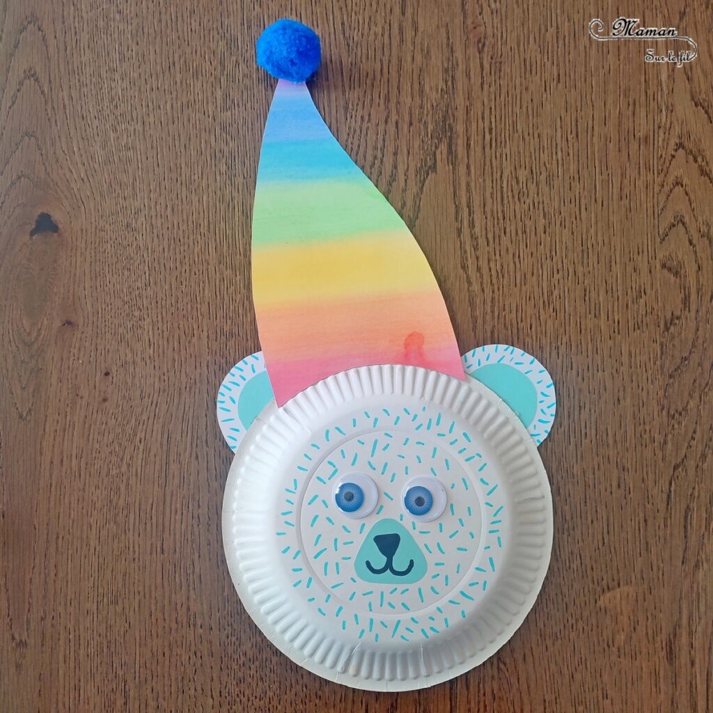 Fabriquer un ours polaire et son bonnet arc-en-ciel (avec une assiette en carton) : activité créative, récup' et manuelle enfants - Peinture, couleurs de l'arc-en-ciel, découpage, collage de papier - Pompon, yeux mobiles, dessin et graphismes - Bricolage sympa pour une décoration hivernale - Surcyclage - Arts visuels et Bricolage - Thème hiver, animaux de la banquise et du froid - Bricolage facile et rapide - Arts visuels et atelier Maternelle et élémentaire - Créativité - Cycle 1 ou 2 - tutoriel photos - mslf