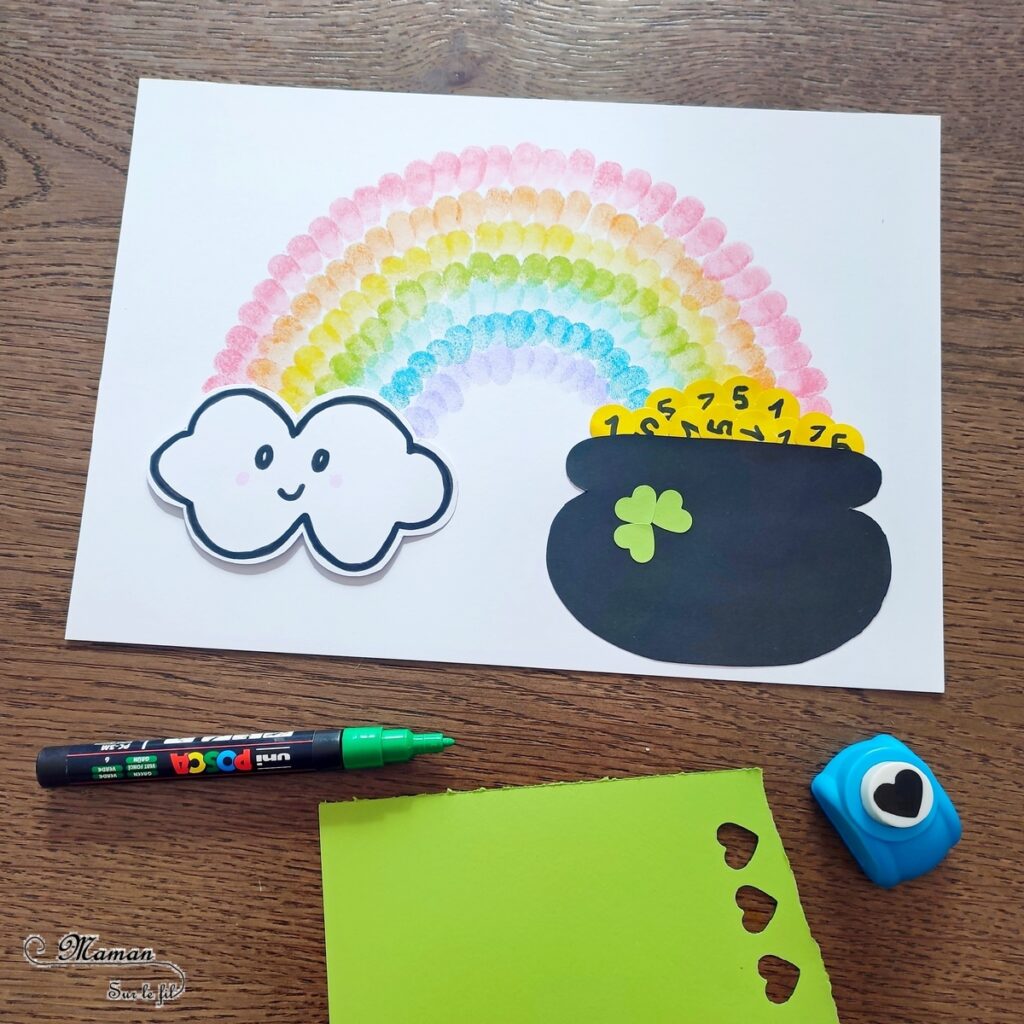 Créer un arc-en-ciel de la Saint-Patrick en empreintes de doigts : activité créative et manuelle enfants - Empreintes de doigts faites avec de l'encre pour tampons - 3 formes de coeur à la perforatrice pour créer les trèfles - Découpage, collage - Dessin et écriture - Chaudron, trésor, pièces, nuages - Arts visuels et Bricolage - Thème Trèfles, Saint-Patrick, Irlande, Géographie, autour du monde - Découverte d'un pays - Bricolage facile et rapide - Arts visuels et atelier Maternelle et élémentaire - Créativité - Cycle 1 ou 2 - tutoriel photos - mslf