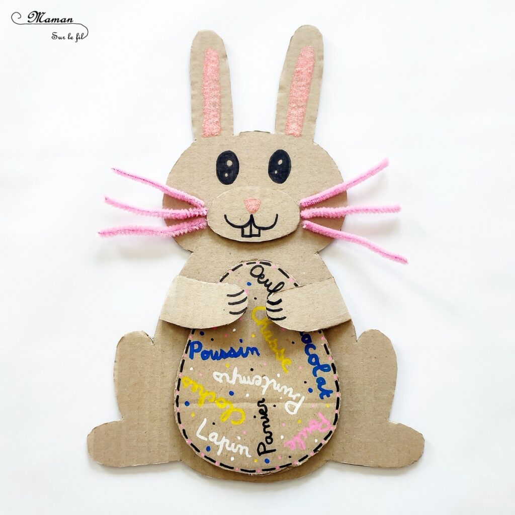 Fabriquer un lapin et son oeuf de Pâques en carton : activité créative, récup' et manuelle enfants - Lapin qui tient un oeuf de Pâques recto-verso dans les pattes - Découpage, collage, chutes de papier, fils chenille - Récup', recyclage, surcyclage de carton - Apport pédagogique et éducatif : champ lexical de Pâques ou Poésie au verso de l'oeuf - Colle pailletée, Glitter glue Uhu - Bricolage sympa et rigolo - Arts visuels et Vocabulaire - Thème Pâques, animaux de la ferme, de la campagne - Arts visuels et atelier Maternelle et élémentaire - Créativité - Cycle 1 ou 2 - tutoriel photos - mslf