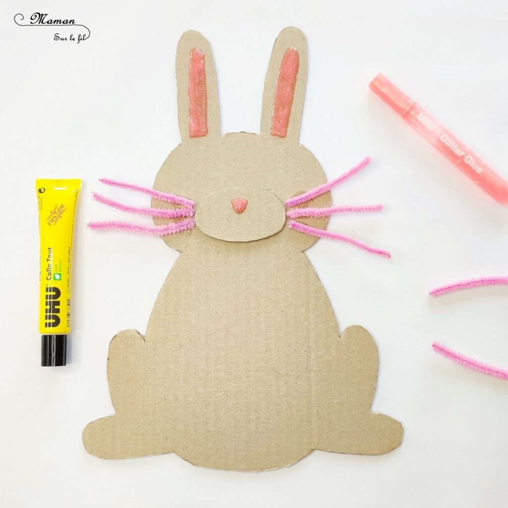 Fabriquer un lapin et son oeuf de Pâques en carton : activité créative, récup' et manuelle enfants - Lapin qui tient un oeuf de Pâques recto-verso dans les pattes - Découpage, collage, chutes de papier, fils chenille - Récup', recyclage, surcyclage de carton - Apport pédagogique et éducatif : champ lexical de Pâques ou Poésie au verso de l'oeuf - Colle pailletée, Glitter glue Uhu - Bricolage sympa et rigolo - Arts visuels et Vocabulaire - Thème Pâques, animaux de la ferme, de la campagne - Arts visuels et atelier Maternelle et élémentaire - Créativité - Cycle 1 ou 2 - tutoriel photos - mslf