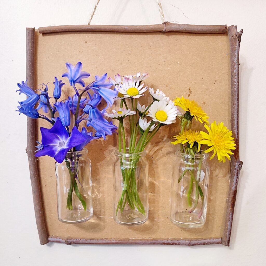 Créer un tableau à fleurir à volonté et au fil des saisons en récup' : activité créative, récup' et manuelle enfants - Tableau en carton, cadre avec des branches, accroche avec de la corde, mini vases avec des petits bocaux en verre (recyclage de boites de médicaments) - A remplir et décorer en fonction des saisons - Surcyclage, recyclage - Décoration - Arts visuels et Bricolage - Thème Fleurs, jardin, printemps, Land art - Bricolage facile et rapide - Arts visuels et atelier Maternelle et élémentaire - Créativité - Cycle 1 ou 2 - tutoriel photos - mslf