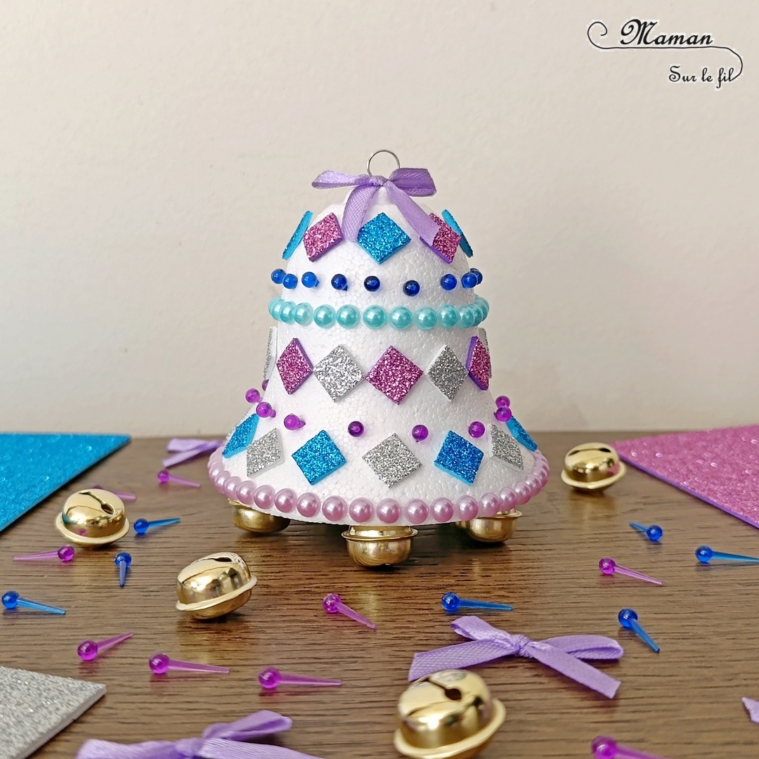 Décorer une cloche de Pâques pailletée en polystyrène : activité créative et manuelle enfants - Le tutoriel et tout le matériel viennent de chez 10 Doigts - Bricolage et décoration DIY réalisé à partir d'une cloche en polystyrène - Décorée avec des gommettes mosaïques brillantes, des bandes de strass et des épingles en plastique à piquer - Ajout d'un crochet pour la suspendre, d'un noeud et de grelots en dessous - Bricolage Fait maison, décoration - Kit tout compris - Thème Pâques, chasse aux oeufs, Noël - Bricolage sympa et facile - Arts visuels Maternelle et cycle 2 - Maternelle et élémentaire - Créativité - Cycle 1 ou 2 - tutoriel photos - mslf