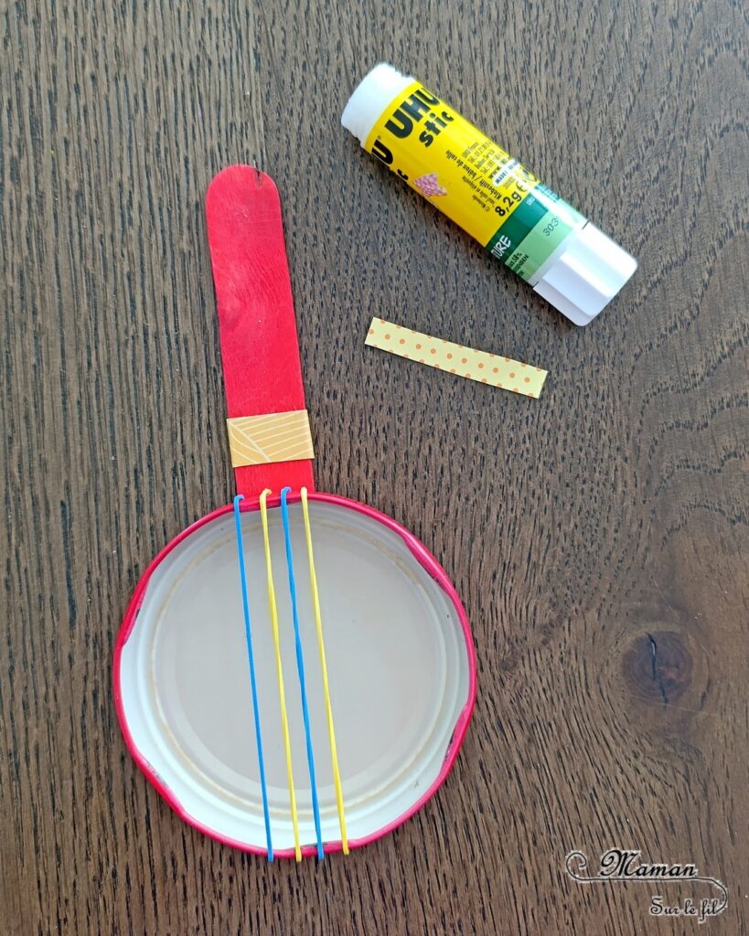 Fabriquer des mini banjos colorés en récup' : activité créative, récup et manuelle enfants - Recyclage, surcyclage de bouchons métalliques, d'élastiques et de bâtonnets en bois colorés - Bricolage rapide pour la fête de la musique - Découpage et collage de papier à motifs - Instruments de musique DIY, fait maison - Thème Fête de la musique - Bricolage et décoration sympa et facile - Arts visuels maternelle et élémentaire - Cycles 1 et 2 - Créativité - tutoriel photos - mslf