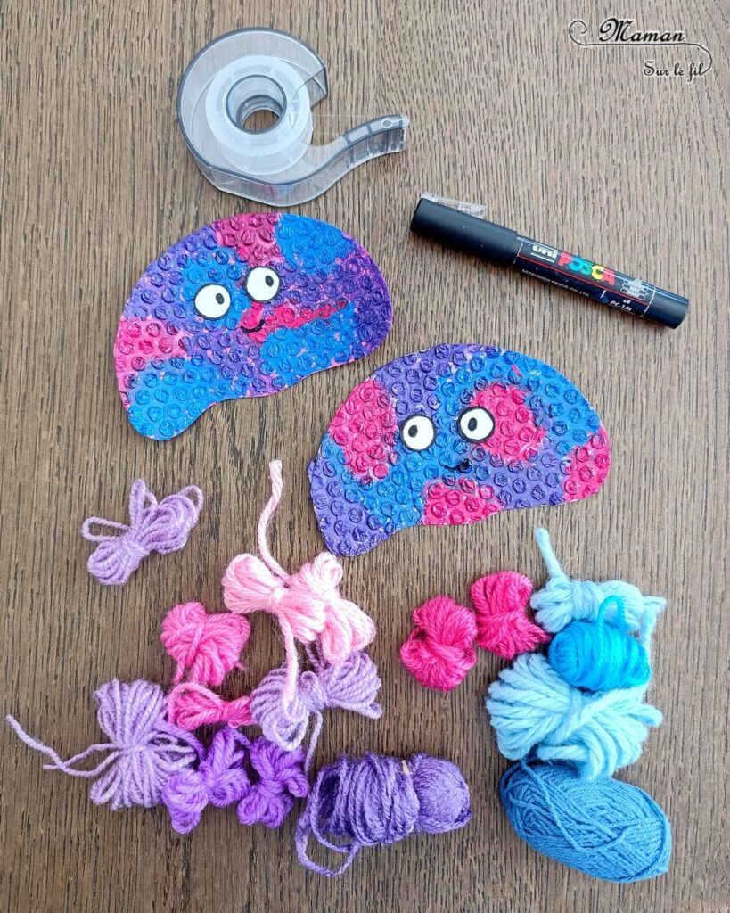 Fabriquer des méduses en papier à bulles et laine : activité créative, peinture, récup' et manuelle enfants - Recyclage et Surcyclage de papier à bulles et de chutes de laines et fils - Peinture rose, bleue, violette sur le papier à bulles - Consolidation avec du papier cartonné - Scotchage de la laine au dos - Yeux rigolos - Bricolage facile et rigolo - Thème animaux marins, océans, mer, été - Bricolage et décoration sympa et facile - Arts visuels maternelle et élémentaire - Cycles 1 et 2 - Créativité - tutoriel photos - mslf