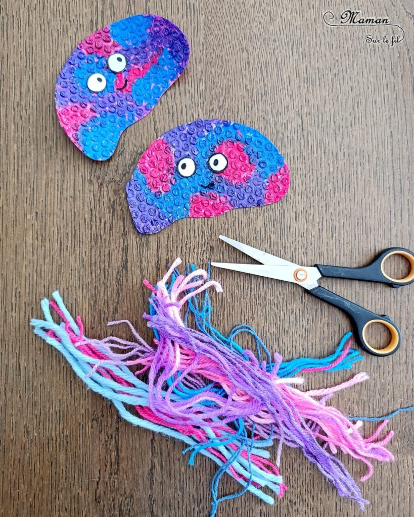 Fabriquer des méduses en papier à bulles et laine : activité créative, peinture, récup' et manuelle enfants - Recyclage et Surcyclage de papier à bulles et de chutes de laines et fils - Peinture rose, bleue, violette sur le papier à bulles - Consolidation avec du papier cartonné - Scotchage de la laine au dos - Yeux rigolos - Bricolage facile et rigolo - Thème animaux marins, océans, mer, été - Bricolage et décoration sympa et facile - Arts visuels maternelle et élémentaire - Cycles 1 et 2 - Créativité - tutoriel photos - mslf