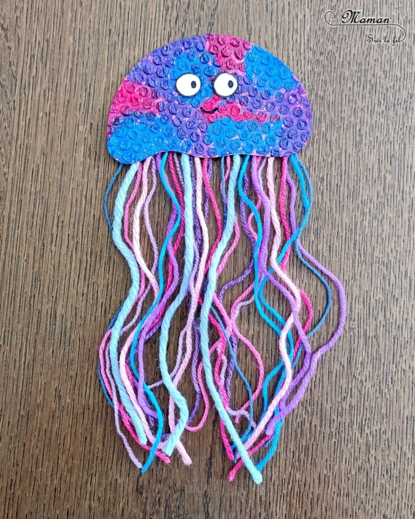 Fabriquer des méduses en papier à bulles et laine : activité créative, peinture, récup' et manuelle enfants - Recyclage et Surcyclage de papier à bulles et de chutes de laines et fils - Peinture rose, bleue, violette sur le papier à bulles - Consolidation avec du papier cartonné - Scotchage de la laine au dos - Yeux rigolos - Bricolage facile et rigolo - Thème animaux marins, océans, mer, été - Bricolage et décoration sympa et facile - Arts visuels maternelle et élémentaire - Cycles 1 et 2 - Créativité - tutoriel photos - mslf