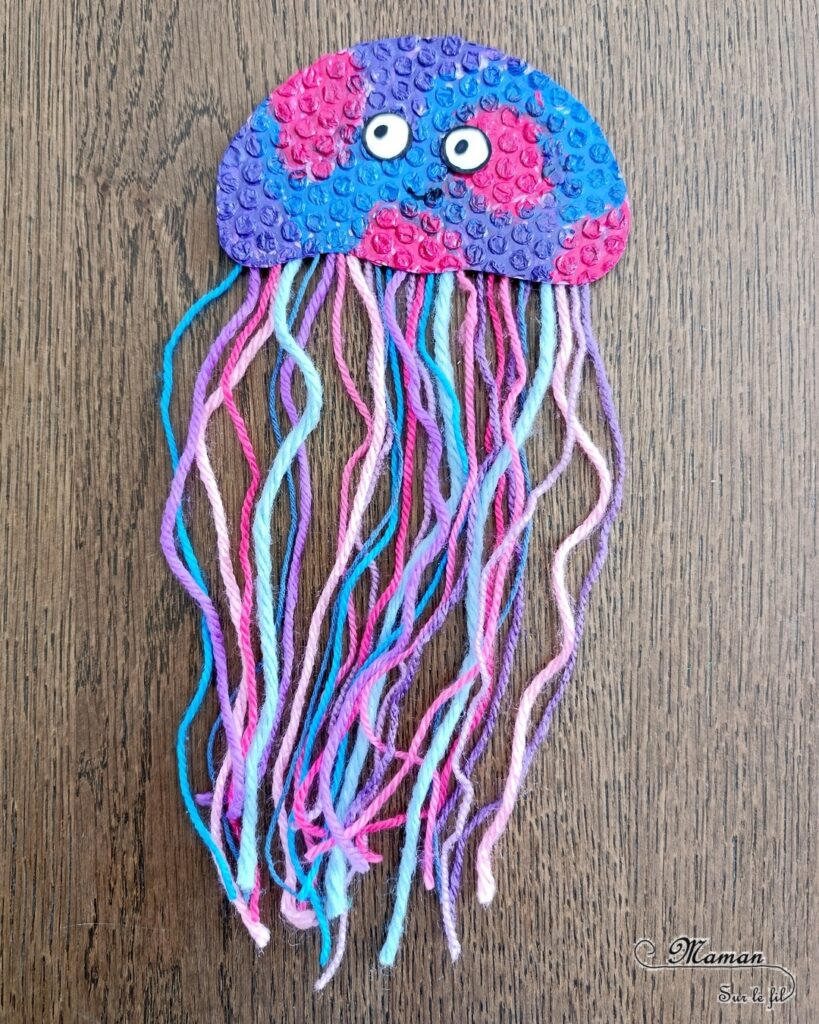 Fabriquer des méduses en papier à bulles et laine : activité créative, peinture, récup' et manuelle enfants - Recyclage et Surcyclage de papier à bulles et de chutes de laines et fils - Peinture rose, bleue, violette sur le papier à bulles - Consolidation avec du papier cartonné - Scotchage de la laine au dos - Yeux rigolos - Bricolage facile et rigolo - Thème animaux marins, océans, mer, été - Bricolage et décoration sympa et facile - Arts visuels maternelle et élémentaire - Cycles 1 et 2 - Créativité - tutoriel photos - mslf