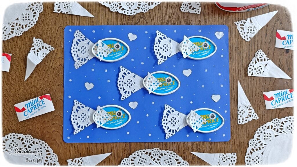 Créer des poissons en récup' de boites à fromage de type Caprice des dieux : activité créative, récup' et manuelle enfants - Recyclage et surcyclage de boites de fromage Caprice des dieux version Mini - Queue et nageoire des poissons avec des napperons - Coeurs et amour -Découpage et collage - Bricolage facile et rigolo - Gommettes Yeux - Thème poissons, animaux marins, mer, océans, été, 1er avril, amour, saint-valentin - Bricolage et décoration sympa et facile - Arts visuels maternelle et élémentaire - Cycles 1 et 2 - Créativité - tutoriel photos - mslf