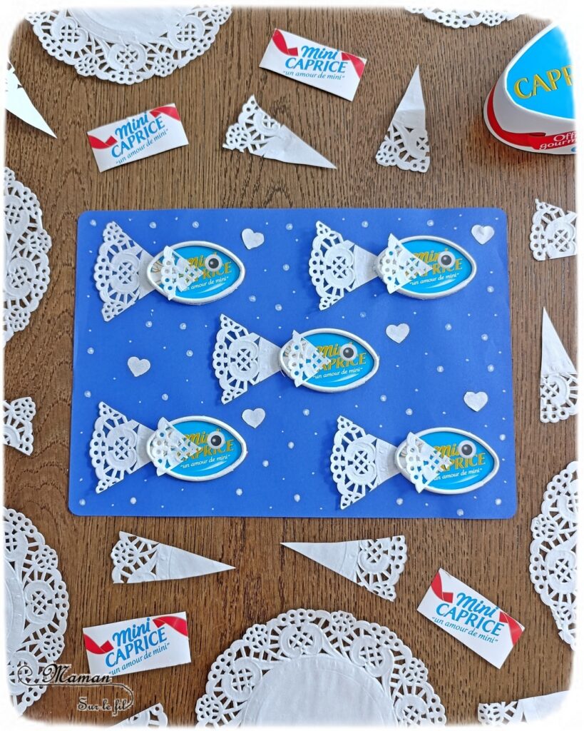 Créer des poissons en récup' de boites à fromage de type Caprice des dieux : activité créative, récup' et manuelle enfants - Recyclage et surcyclage de boites de fromage Caprice des dieux version Mini - Queue et nageoire des poissons avec des napperons - Coeurs et amour -Découpage et collage - Bricolage facile et rigolo - Gommettes Yeux - Thème poissons, animaux marins, mer, océans, été, 1er avril, amour, saint-valentin - Bricolage et décoration sympa et facile - Arts visuels maternelle et élémentaire - Cycles 1 et 2 - Créativité - tutoriel photos - mslf