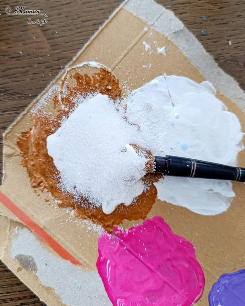 Créer des cabanes de plage avec des bâtonnets de glace en bois : activité créative, récup', peinture et manuelle enfants - Peindre les bâtonnets de bois en blanc et en couleur - Cabanes de plages rayées en récup'- Ouverture en forme de coeur - Collés sur un fond peint à l'aquarelle bleue pour le ciel et peinture marron + sable pour le sable - Effet de volume et de texture - Coquillages en décoration - Dessin et graphismes pour les oiseaux - Bricolage facile et rapide - Thème été, vacances, plage, mer - Bricolage et décoration sympa et facile - Arts visuels maternelle et élémentaire - Cycles 1 et 2 - Créativité - tutoriel photos - mslf