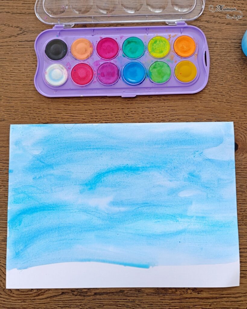 Créer des cabanes de plage avec des bâtonnets de glace en bois : activité créative, récup', peinture et manuelle enfants - Peindre les bâtonnets de bois en blanc et en couleur - Cabanes de plages rayées en récup'- Ouverture en forme de coeur - Collés sur un fond peint à l'aquarelle bleue pour le ciel et peinture marron + sable pour le sable - Effet de volume et de texture - Coquillages en décoration - Dessin et graphismes pour les oiseaux - Bricolage facile et rapide - Thème été, vacances, plage, mer - Bricolage et décoration sympa et facile - Arts visuels maternelle et élémentaire - Cycles 1 et 2 - Créativité - tutoriel photos - mslf