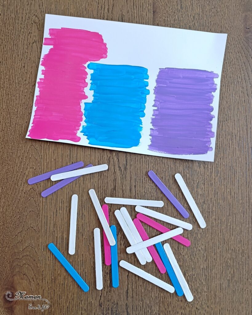 Créer des cabanes de plage avec des bâtonnets de glace en bois : activité créative, récup', peinture et manuelle enfants - Peindre les bâtonnets de bois en blanc et en couleur - Cabanes de plages rayées en récup'- Ouverture en forme de coeur - Collés sur un fond peint à l'aquarelle bleue pour le ciel et peinture marron + sable pour le sable - Effet de volume et de texture - Coquillages en décoration - Dessin et graphismes pour les oiseaux - Bricolage facile et rapide - Thème été, vacances, plage, mer - Bricolage et décoration sympa et facile - Arts visuels maternelle et élémentaire - Cycles 1 et 2 - Créativité - tutoriel photos - mslf