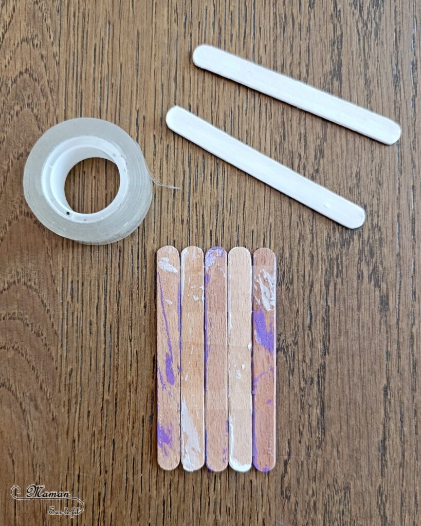 Créer des cabanes de plage avec des bâtonnets de glace en bois : activité créative, récup', peinture et manuelle enfants - Peindre les bâtonnets de bois en blanc et en couleur - Cabanes de plages rayées en récup'- Ouverture en forme de coeur - Collés sur un fond peint à l'aquarelle bleue pour le ciel et peinture marron + sable pour le sable - Effet de volume et de texture - Coquillages en décoration - Dessin et graphismes pour les oiseaux - Bricolage facile et rapide - Thème été, vacances, plage, mer - Bricolage et décoration sympa et facile - Arts visuels maternelle et élémentaire - Cycles 1 et 2 - Créativité - tutoriel photos - mslf