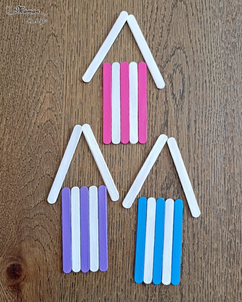 Créer des cabanes de plage avec des bâtonnets de glace en bois : activité créative, récup', peinture et manuelle enfants - Peindre les bâtonnets de bois en blanc et en couleur - Cabanes de plages rayées en récup'- Ouverture en forme de coeur - Collés sur un fond peint à l'aquarelle bleue pour le ciel et peinture marron + sable pour le sable - Effet de volume et de texture - Coquillages en décoration - Dessin et graphismes pour les oiseaux - Bricolage facile et rapide - Thème été, vacances, plage, mer - Bricolage et décoration sympa et facile - Arts visuels maternelle et élémentaire - Cycles 1 et 2 - Créativité - tutoriel photos - mslf