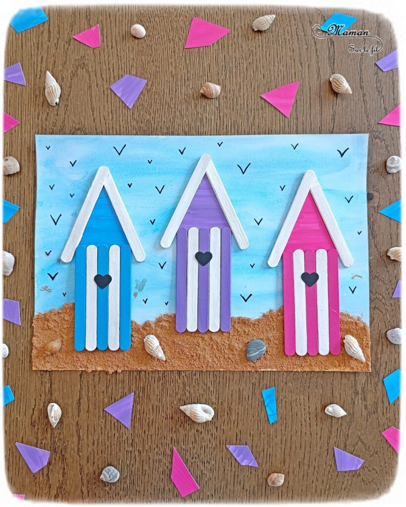 Créer des cabanes de plage avec des bâtonnets de glace en bois : activité créative, récup', peinture et manuelle enfants - Peindre les bâtonnets de bois en blanc et en couleur - Cabanes de plages rayées en récup'- Ouverture en forme de coeur - Collés sur un fond peint à l'aquarelle bleue pour le ciel et peinture marron + sable pour le sable - Effet de volume et de texture - Coquillages en décoration - Dessin et graphismes pour les oiseaux - Bricolage facile et rapide - Thème été, vacances, plage, mer - Bricolage et décoration sympa et facile - Arts visuels maternelle et élémentaire - Cycles 1 et 2 - Créativité - tutoriel photos - mslf