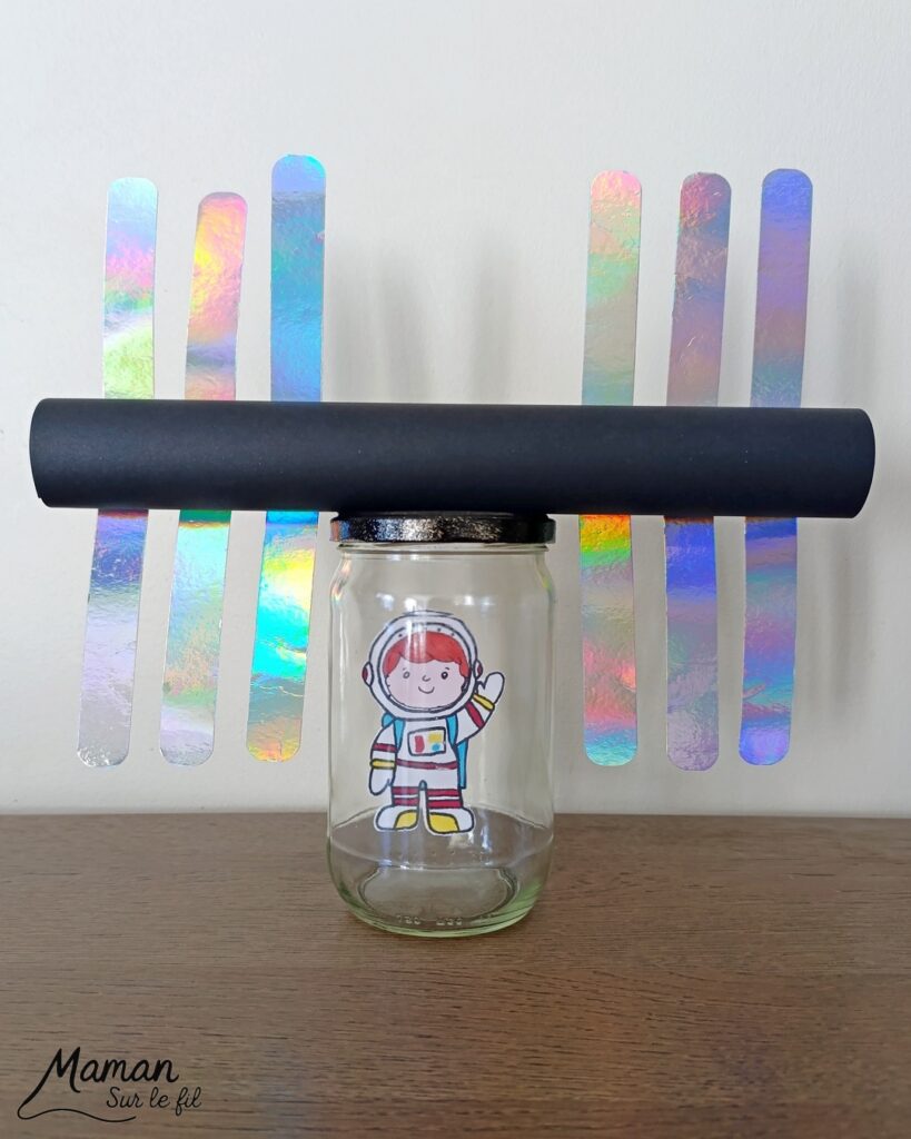 Fabriquer un petit astronaute qui flotte comme en apesanteur dans une ISS miniature : activité créative, récup' et manuelle enfants - Station Spatiale Internationale imaginée avec un bocal en verre surcyclé - Papier brillant et holographique, rouleau en carton, peinture - Dessin et coloriage pour le cosmonaute - Suspendu avec un fil invisible et du scotch - Bricolage et décoration DIY et facile - Bricolage Fait maison, décoration - Thème Nuit, Ciel, Espace, étoiles, fusées - Bricolage sympa et facile - Arts visuels Maternelle et cycle 2 - Maternelle et élémentaire - Créativité - Cycle 1 ou 2 - tutoriel photos et vidéo - mslf