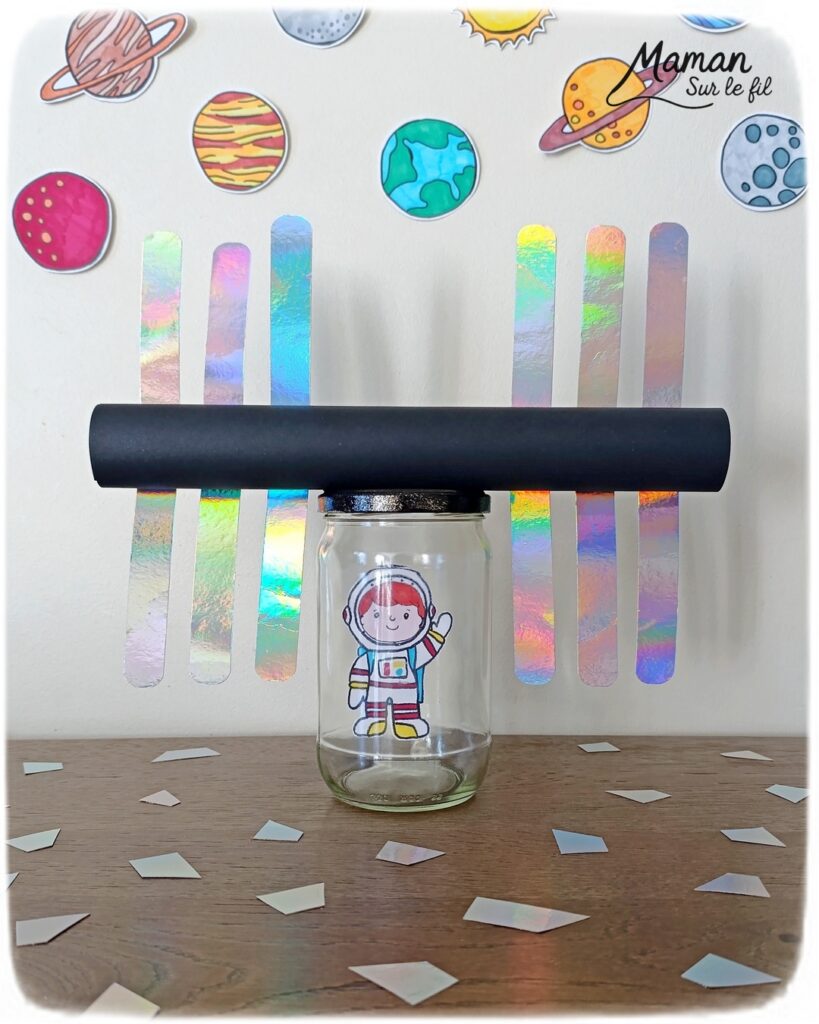 Fabriquer un petit astronaute qui flotte comme en apesanteur dans une ISS miniature : activité créative, récup' et manuelle enfants - Station Spatiale Internationale imaginée avec un bocal en verre surcyclé - Papier brillant et holographique, rouleau en carton, peinture - Dessin et coloriage pour le cosmonaute - Suspendu avec un fil invisible et du scotch - Bricolage et décoration DIY et facile - Bricolage Fait maison, décoration - Thème Nuit, Ciel, Espace, étoiles, fusées - Bricolage sympa et facile - Arts visuels Maternelle et cycle 2 - Maternelle et élémentaire - Créativité - Cycle 1 ou 2 - tutoriel photos et vidéo - mslf