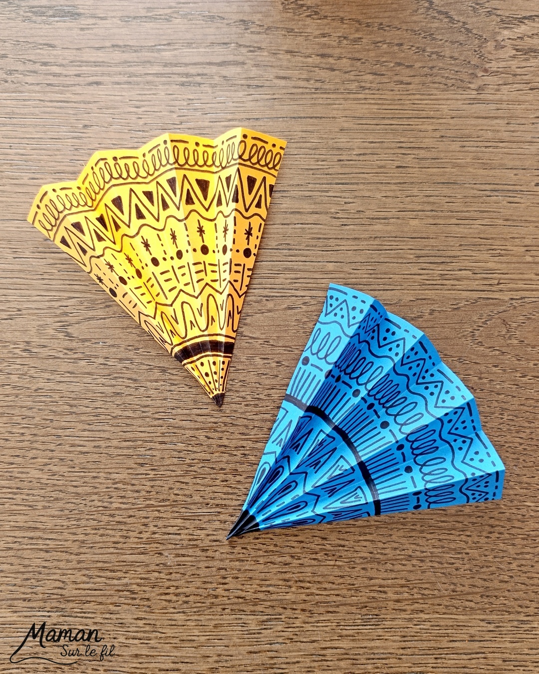 Créer des parapluies graphiques en volume : activité créative, papier et manuelle enfants - Dessin de cercles au compas - Graphismes et dessins noirs pour les décors du parapluie - Découpage et pliage pour l'accordéon - Collage et dessins pour donner l'impression que les parapluies sont posés sous la pluie - Traits obliques - Bricolage et décoration DIY et facile - Bricolage Fait maison, décoration - Thème Météo, Pluie, Nuage, Ciel, Automne - Bricolage sympa et facile - Arts visuels Maternelle et cycle 2 - Maternelle et élémentaire - Créativité - Cycle 1 ou 2 - tutoriel photos - mslf