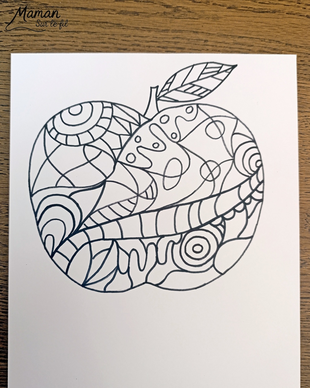 Dessiner et colorier une pomme graphique et son cadre en laine : activité créative, dessin, motricité fine et manuelle enfants - Dessin de la pomme et des graphismes intérieurs au feutre noir - Coloriage aux couleurs des pommes : jaune, vert et rouge - Découpage et collage sur fond noir pour contraste - Cadre tissé en laine rouge - Bricolage et décoration DIY et facile - Bricolage Fait maison, décoration - Création façon art thérapie ou zen art - Thème pommes, fruits et légumes, potager, verger, automne - Bricolage sympa et facile - Arts visuels Maternelle et cycle 2 - Maternelle et élémentaire - Créativité - Cycle 1 ou 2 - tutoriel photos - mslf