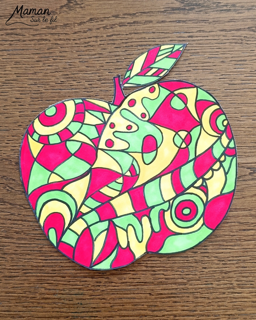 Dessiner et colorier une pomme graphique et son cadre en laine : activité créative, dessin, motricité fine et manuelle enfants - Dessin de la pomme et des graphismes intérieurs au feutre noir - Coloriage aux couleurs des pommes : jaune, vert et rouge - Découpage et collage sur fond noir pour contraste - Cadre tissé en laine rouge - Bricolage et décoration DIY et facile - Bricolage Fait maison, décoration - Création façon art thérapie ou zen art - Thème pommes, fruits et légumes, potager, verger, automne - Bricolage sympa et facile - Arts visuels Maternelle et cycle 2 - Maternelle et élémentaire - Créativité - Cycle 1 ou 2 - tutoriel photos - mslf