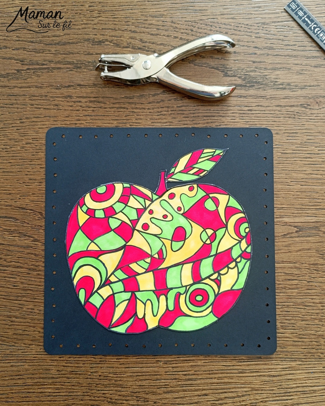 Dessiner et colorier une pomme graphique et son cadre en laine : activité créative, dessin, motricité fine et manuelle enfants - Dessin de la pomme et des graphismes intérieurs au feutre noir - Coloriage aux couleurs des pommes : jaune, vert et rouge - Découpage et collage sur fond noir pour contraste - Cadre tissé en laine rouge - Bricolage et décoration DIY et facile - Bricolage Fait maison, décoration - Création façon art thérapie ou zen art - Thème pommes, fruits et légumes, potager, verger, automne - Bricolage sympa et facile - Arts visuels Maternelle et cycle 2 - Maternelle et élémentaire - Créativité - Cycle 1 ou 2 - tutoriel photos - mslf