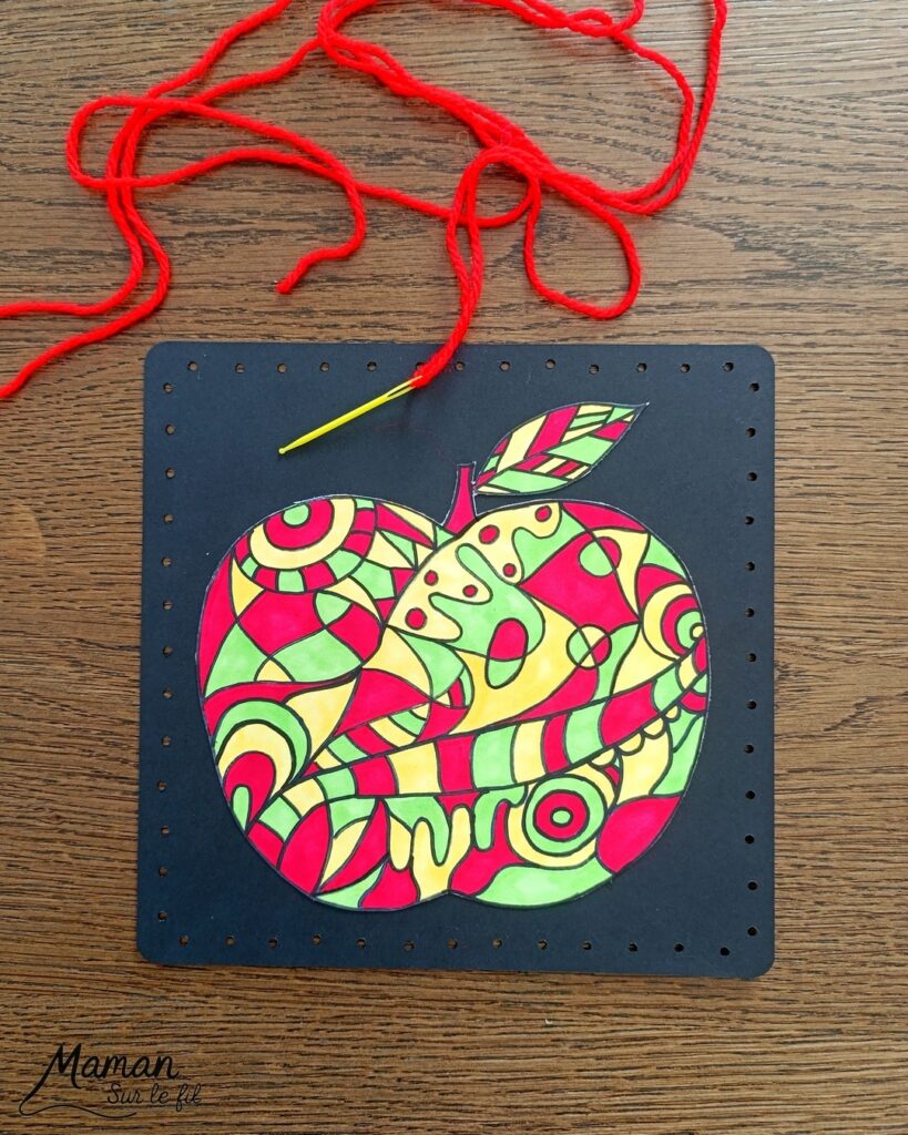 Dessiner et colorier une pomme graphique et son cadre en laine : activité créative, dessin, motricité fine et manuelle enfants - Dessin de la pomme et des graphismes intérieurs au feutre noir - Coloriage aux couleurs des pommes : jaune, vert et rouge - Découpage et collage sur fond noir pour contraste - Cadre tissé en laine rouge - Bricolage et décoration DIY et facile - Bricolage Fait maison, décoration - Création façon art thérapie ou zen art - Thème pommes, fruits et légumes, potager, verger, automne - Bricolage sympa et facile - Arts visuels Maternelle et cycle 2 - Maternelle et élémentaire - Créativité - Cycle 1 ou 2 - tutoriel photos - mslf