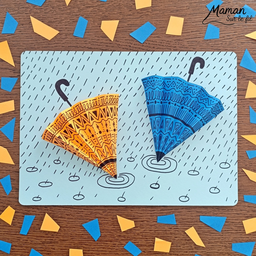 Créer des parapluies graphiques en volume : activité créative, papier et manuelle enfants - Dessin de cercles au compas - Graphismes et dessins noirs pour les décors du parapluie - Découpage et pliage pour l'accordéon - Collage et dessins pour donner l'impression que les parapluies sont posés sous la pluie - Traits obliques - Bricolage et décoration DIY et facile - Bricolage Fait maison, décoration - Thème Météo, Pluie, Nuage, Ciel, Automne - Bricolage sympa et facile - Arts visuels Maternelle et cycle 2 - Maternelle et élémentaire - Créativité - Cycle 1 ou 2 - tutoriel photos - mslf