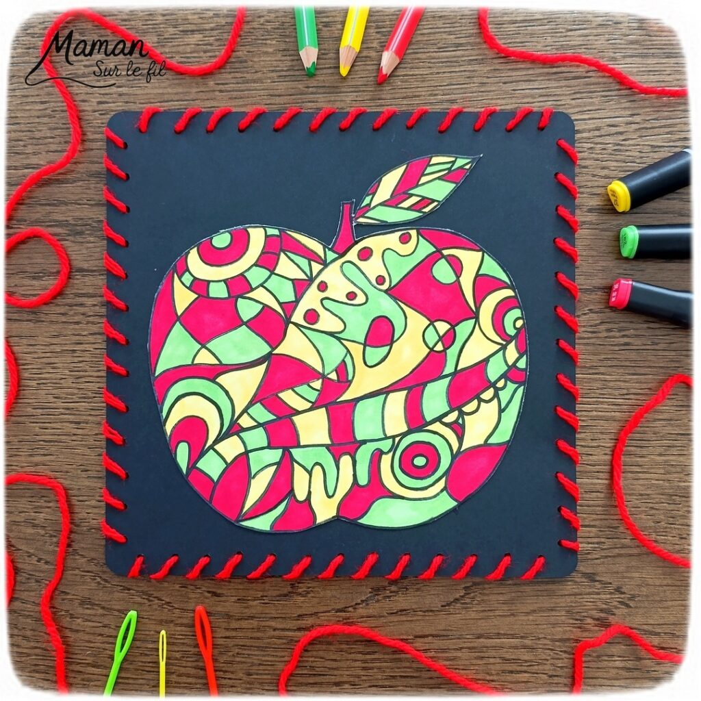 Dessiner et colorier une pomme graphique et son cadre en laine : activité créative, dessin, motricité fine et manuelle enfants - Dessin de la pomme et des graphismes intérieurs au feutre noir - Coloriage aux couleurs des pommes : jaune, vert et rouge - Découpage et collage sur fond noir pour contraste - Cadre tissé en laine rouge - Bricolage et décoration DIY et facile - Bricolage Fait maison, décoration - Création façon art thérapie ou zen art - Thème pommes, fruits et légumes, potager, verger, automne - Bricolage sympa et facile - Arts visuels Maternelle et cycle 2 - Maternelle et élémentaire - Créativité - Cycle 1 ou 2 - tutoriel photos - mslf