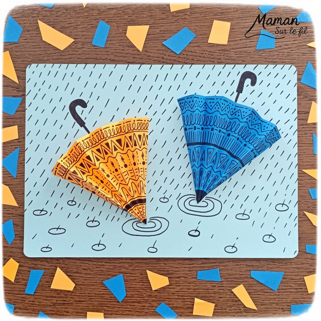 Créer des parapluies graphiques en volume : activité créative, papier et manuelle enfants - Dessin de cercles au compas - Graphismes et dessins noirs pour les décors du parapluie - Découpage et pliage pour l'accordéon - Collage et dessins pour donner l'impression que les parapluies sont posés sous la pluie - Traits obliques - Bricolage et décoration DIY et facile - Bricolage Fait maison, décoration - Thème Météo, Pluie, Nuage, Ciel, Automne - Bricolage sympa et facile - Arts visuels Maternelle et cycle 2 - Maternelle et élémentaire - Créativité - Cycle 1 ou 2 - tutoriel photos - mslf