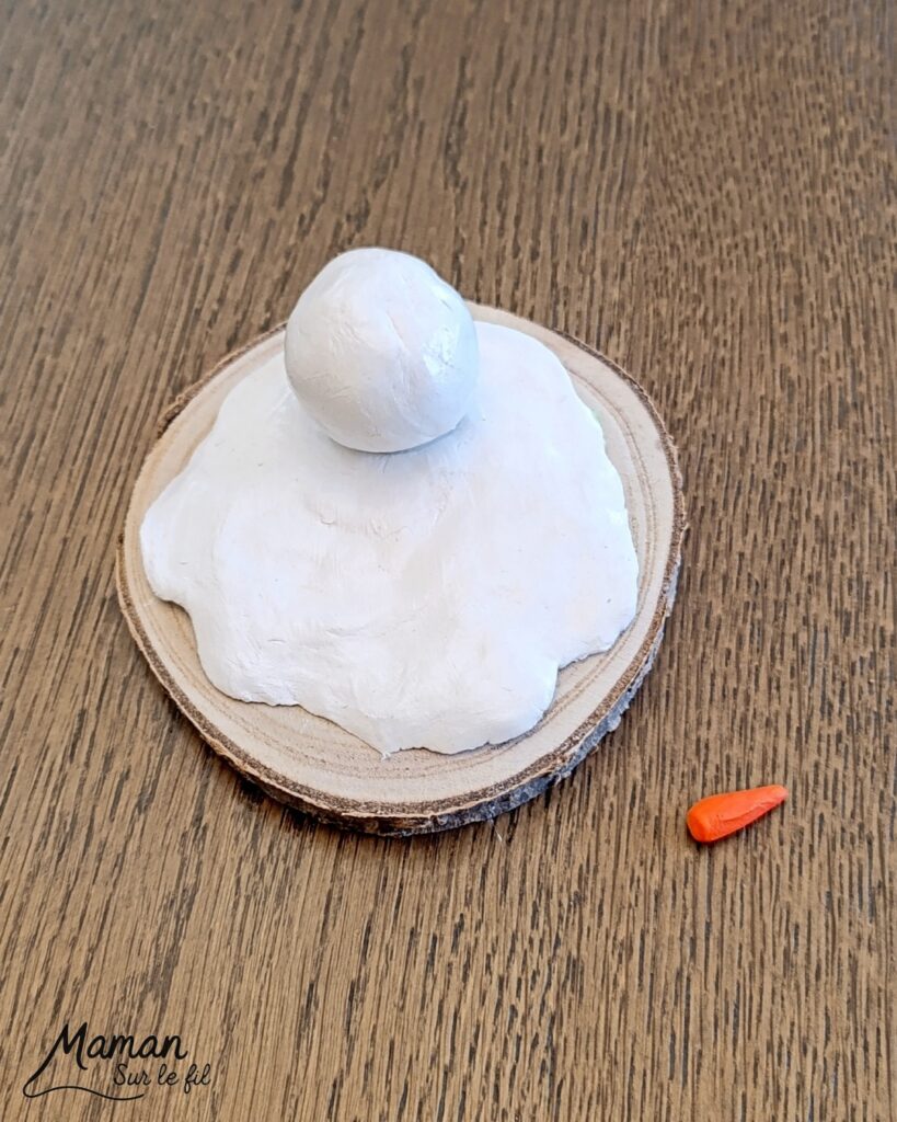 Fabriquer un bonhomme de neige fondu en pâte autodurcissante - activité créative et manuelle enfants - Décoration DIY et rigolote - Modelage, peinture, collage - Feutrine pour le chapeau, boutons et branches pour les bras - Le tout sur rondin de bois et napperon blanc - Bricolage et décoration DIY - Bricolage Fait maison, décoration - Thème Hiver, froid, neige - Bricolage sympa et facile - Arts visuels Maternelle et cycle 2 - Maternelle et élémentaire - Créativité - Cycle 1 ou 2 - tutoriel photos - mslf