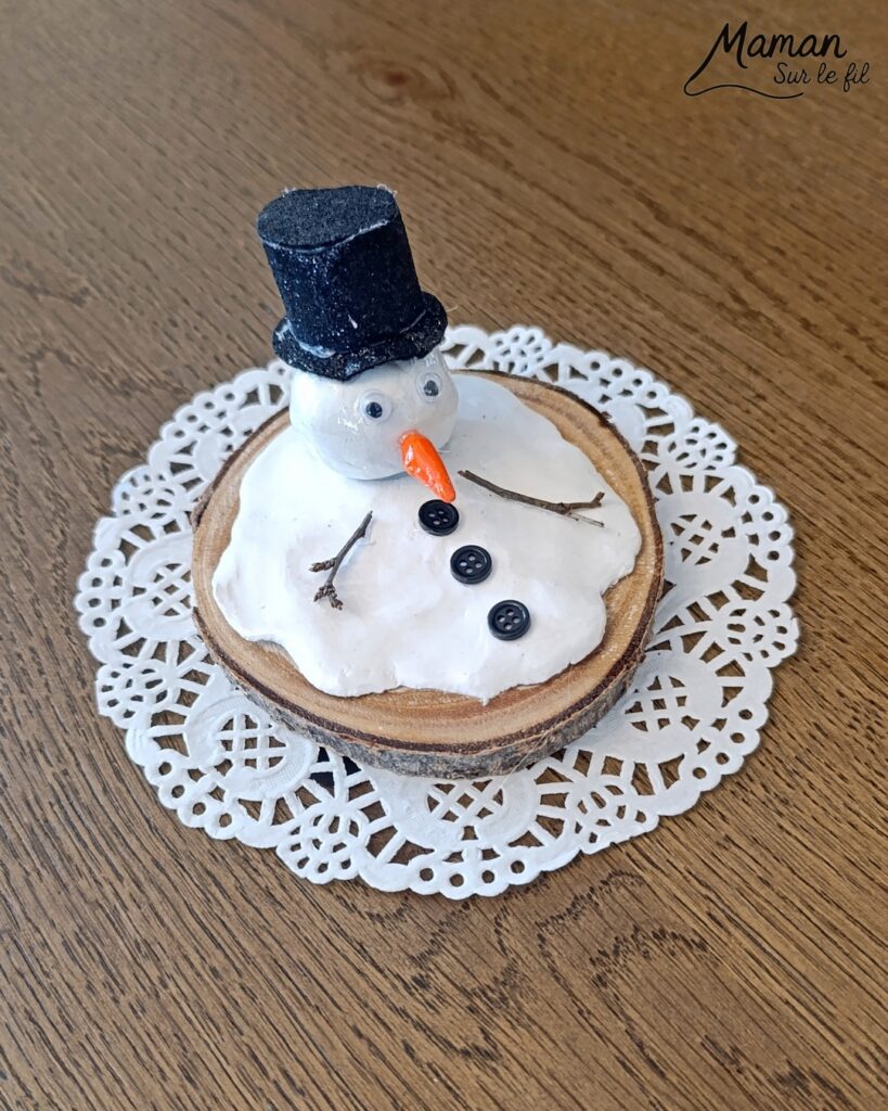 Fabriquer un bonhomme de neige fondu en pâte autodurcissante - activité créative et manuelle enfants - Décoration DIY et rigolote - Modelage, peinture, collage - Feutrine pour le chapeau, boutons et branches pour les bras - Le tout sur rondin de bois et napperon blanc - Bricolage et décoration DIY - Bricolage Fait maison, décoration - Thème Hiver, froid, neige - Bricolage sympa et facile - Arts visuels Maternelle et cycle 2 - Maternelle et élémentaire - Créativité - Cycle 1 ou 2 - tutoriel photos - mslf