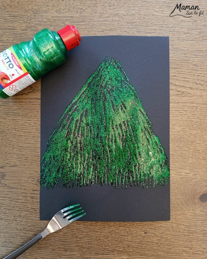 Peindre un sapin pailleté en peinture à la fourchette : activité créative, peinture et manuelle enfants - Technique de peinture rigolote avec peinture pailletée - Fourchette et paille découpée pour l'étoile - Vert et doré - Dessin et graphismes aux feutres blancs et métalliques - Sapin de Noël qui brille - Bricolage DIY facile et rapide - Thème hiver, Noël, fêtes de fin d'année - Décoration DIY - Bricolage et décoration sympa et facile - Arts visuels maternelle et élémentaire - Cycles 1 et 2 - Créativité - tutoriel photos - mslf