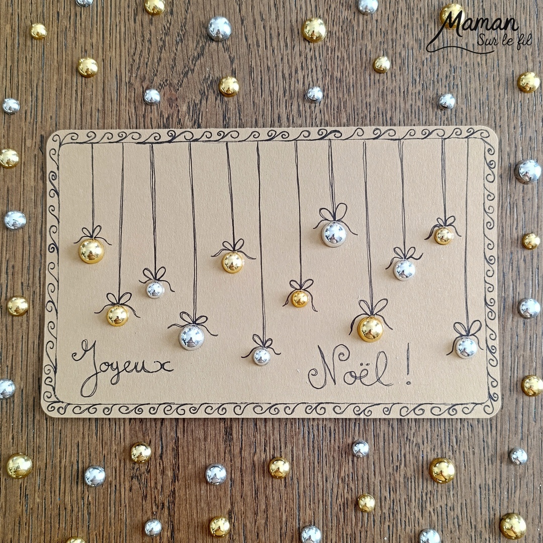 Créer une carte de voeux Boules de Noël avec des cabochons : activité créative et manuelle enfants - Découpage et collage de papier - Collage de demi perles, sequins, cabochons dorés et argentés pour les boules suspendues - Dessins, écriture et graphismes au feutre fin noir - Fond papier couleur Kraft - Cadeau pour les fêtes de fin d'année - Joyeux Noël ou Bonne année - Bricolage joli et décoration DIY et facile - Bricolage Fait maison, décoration - Thème Noël, fêtes de fin d'année, Boules de Noël - Bricolage sympa et facile - Arts visuels Maternelle et cycle 2 - Maternelle et élémentaire - Créativité - Cycle 1 ou 2 - tutoriel photos - mslf