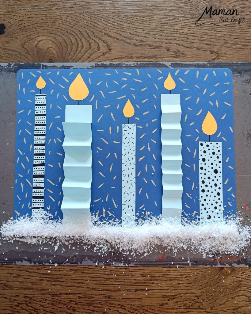 Créer une carte avec des bougies hivernales en papier, pliées en accordéon et décorées de graphismes : activité créative et manuelle enfants - Découpage, pliage et collage de papier - Pliage en accordéon - Dessins et graphismes noirs - Contraste avec couleurs hivernales - Sur lit de fausse neige - Bricolage joli et décoration DIY et facile - Bricolage Fait maison, décoration - Thème Noël, fêtes de fin d'année, cartes de voeux, hiver, cocooning - Bricolage sympa et facile - Arts visuels Maternelle et cycle 2 - Maternelle et élémentaire - Créativité - Cycle 1 ou 2 - tutoriel photos - mslf