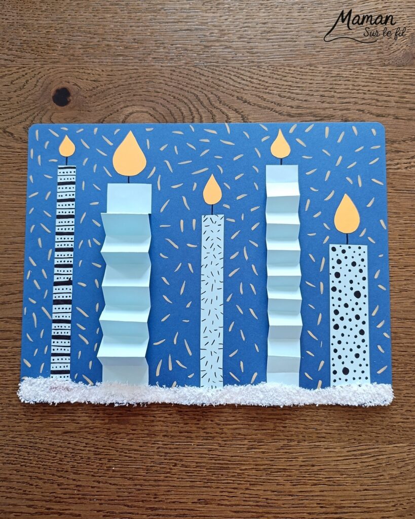 Créer une carte avec des bougies hivernales en papier, pliées en accordéon et décorées de graphismes : activité créative et manuelle enfants - Découpage, pliage et collage de papier - Pliage en accordéon - Dessins et graphismes noirs - Contraste avec couleurs hivernales - Sur lit de fausse neige - Bricolage joli et décoration DIY et facile - Bricolage Fait maison, décoration - Thème Noël, fêtes de fin d'année, cartes de voeux, hiver, cocooning - Bricolage sympa et facile - Arts visuels Maternelle et cycle 2 - Maternelle et élémentaire - Créativité - Cycle 1 ou 2 - tutoriel photos - mslf