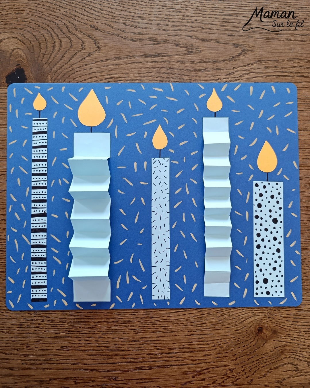 Créer une carte avec des bougies hivernales en papier, pliées en accordéon et décorées de graphismes : activité créative et manuelle enfants - Découpage, pliage et collage de papier - Pliage en accordéon - Dessins et graphismes noirs - Contraste avec couleurs hivernales - Sur lit de fausse neige - Bricolage joli et décoration DIY et facile - Bricolage Fait maison, décoration - Thème Noël, fêtes de fin d'année, cartes de voeux, hiver, cocooning - Bricolage sympa et facile - Arts visuels Maternelle et cycle 2 - Maternelle et élémentaire - Créativité - Cycle 1 ou 2 - tutoriel photos - mslf