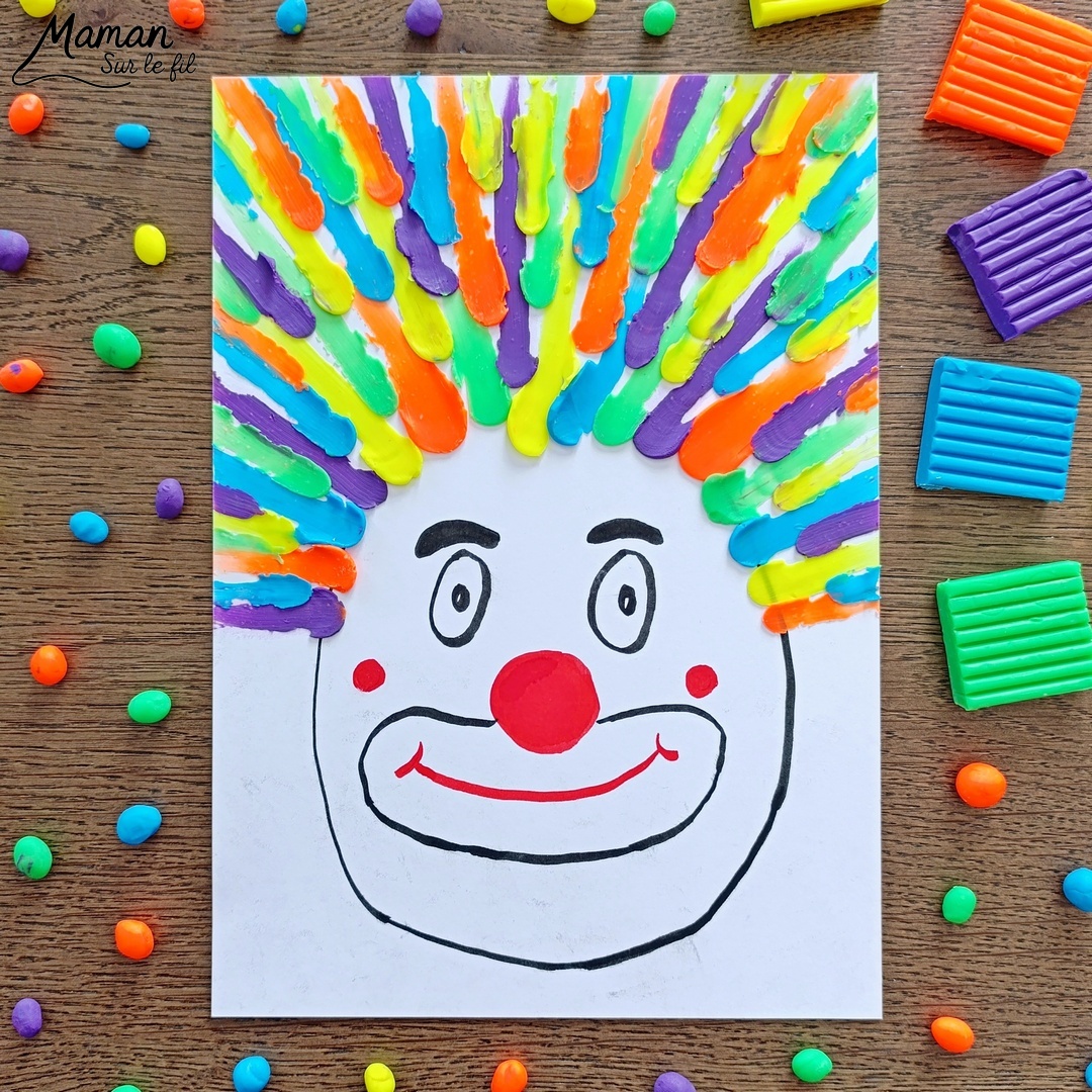 Créer un clown aux cheveux fous en pâte à modeler fluo étalée au doigt : activité créative, sensoriel et manuelle enfants - Dessin d'une tête de clown aux feutres noir et rouge - Cheveux multicolore créés en étalant des boules de pâte à modeler - Motricité fine, musculation des doigts, sensoriel - Bricolage facile, coloré et rigolo - Thème Carnaval, Mardi-Gras, cirque, anniversaire et fêtes - Bricolage et décoration sympa et facile - Arts visuels maternelle et élémentaire - Cycles 1 et 2 - Créativité - tutoriel photos et vidéo - mslf