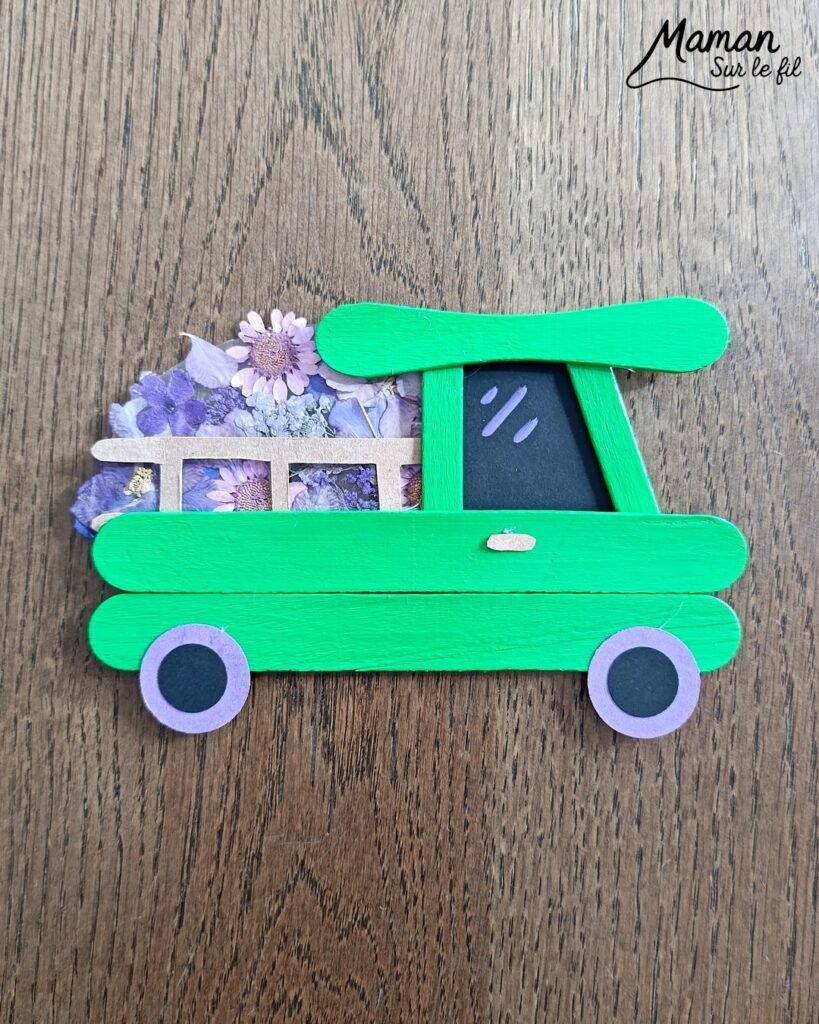 Fabriquer un camion printanier pour le transport des fleurs : activité créative, récup', nature, peinture et manuelle enfants - Recyclage, surcyclage de bâtonnets de glace en bois - Peindre en vert pour rappeler l'herbe du printemps - Carton pour la barrière - Papier pour les roues et la fenêtre - Fleurs séchées collées sur une pochette plastique - Utiliser les trésors du printemps - Land Art, atelier nature, école dehors - Décoration DIY Fait maison - Cadeau DIY, fait maison à offrir - Bricolage facile et rapide - Thème fleurs, nature, printemps, véhicules terrestres - Bricolage et décoration sympa et facile - Arts visuels maternelle et élémentaire - Cycles 1 et 2 - Créativité - tutoriel photos - mslf
