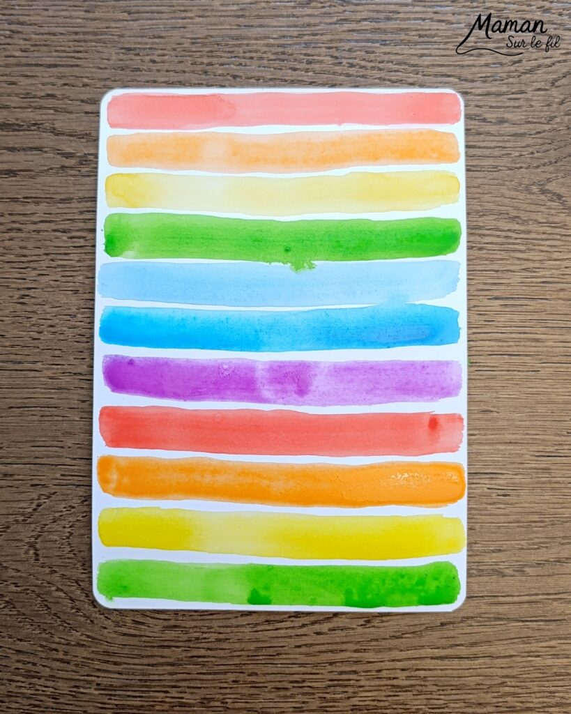 Créer une fleur en noir et blanc sur fond coloré Arc-en-ciel : activité créative, peinture et manuelle enfants - Peinture type aquarelle - Tracé de lignes horizontales aux couleurs de l'arc-en-ciel - Dessin de la fleur au feutre noir - Découpage, collage, contraste - Cadeau DIY, fait maison à offrir - Bricolage facile - Thème fleurs, nature, printemps - Bricolage et décoration sympa et facile - Arts visuels maternelle et élémentaire - Cycles 1 et 2 - Créativité - tutoriel photos - mslf