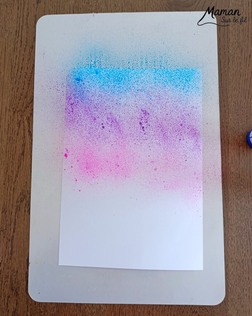 Peindre un oeuf de Pâques avec des empreintes de gommettes en mousse : activité créative, peinture et manuelle enfants - Fond en peinture en spray - Pulvérisation de peinture - Couleurs vives pour contraste avec le noir - Collage de gommettes épaisses en mousse pour créer l'oeuf de Pâques - Peinture noir pour utiliser comme tampon - Décoration DIY Fait maison - Bricolage facile - Thème Pâques, gourmandises, chocolat, oeufs - Bricolage et décoration sympa et facile - Arts visuels maternelle et élémentaire - Cycles 1 et 2 - Créativité - tutoriel photos et vidéo - mslf