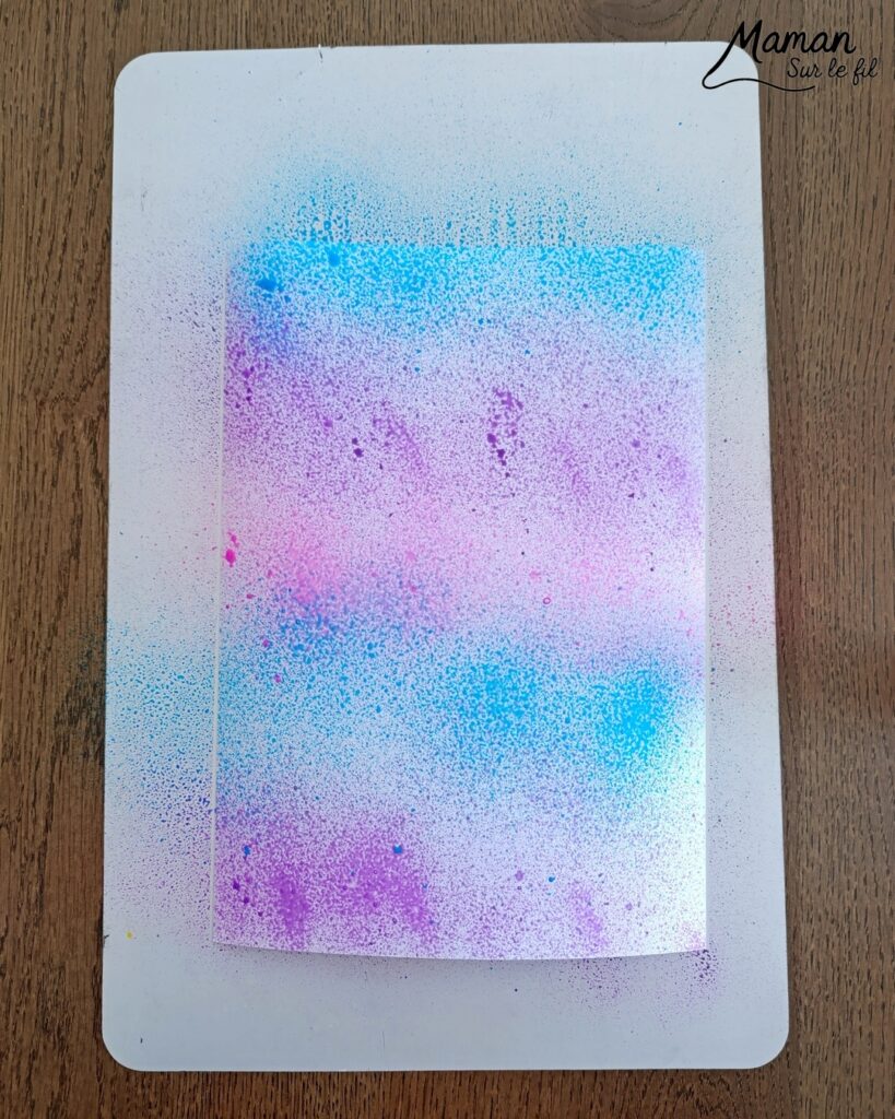 Peindre un oeuf de Pâques avec des empreintes de gommettes en mousse : activité créative, peinture et manuelle enfants - Fond en peinture en spray - Pulvérisation de peinture - Couleurs vives pour contraste avec le noir - Collage de gommettes épaisses en mousse pour créer l'oeuf de Pâques - Peinture noir pour utiliser comme tampon - Décoration DIY Fait maison - Bricolage facile - Thème Pâques, gourmandises, chocolat, oeufs - Bricolage et décoration sympa et facile - Arts visuels maternelle et élémentaire - Cycles 1 et 2 - Créativité - tutoriel photos et vidéo - mslf