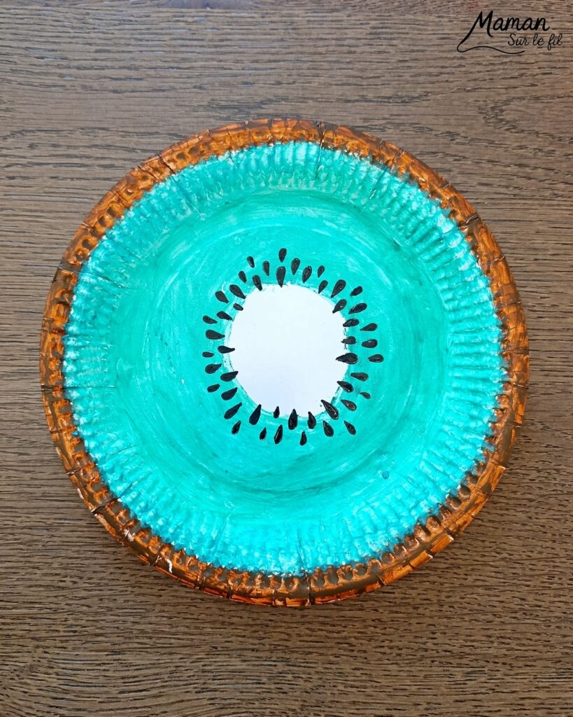Créer un kiwi rigolo avec une assiette en carton : activité créative, peinture et manuelle enfants - Peindre le tour en marron avec de la gouache en stick, puis, le centre en vert - Dessin des pépins - Yeux mobiles flippants et bouche en papier - Décoration DIY Fait maison - Bricolage facile et rapide - Thème fruits et légumes, potager, jardinage, nature, printemps - Bricolage et décoration sympa et facile - Arts visuels maternelle et élémentaire - Cycles 1 et 2 - Créativité - tutoriel photos - mslf